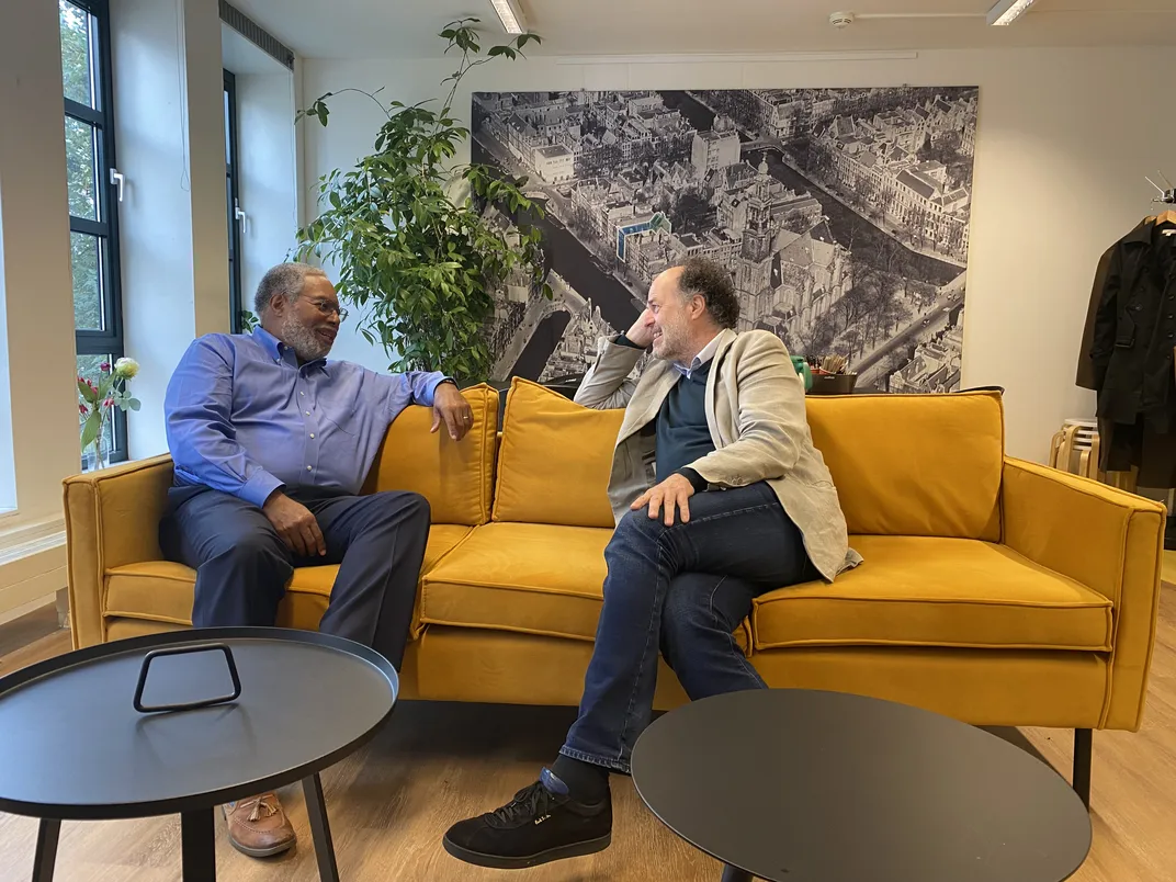Secretary Bunch and Ronald Leopold, Executive Director of the Anne Frank House, sit on a couch together engaged in discussion
