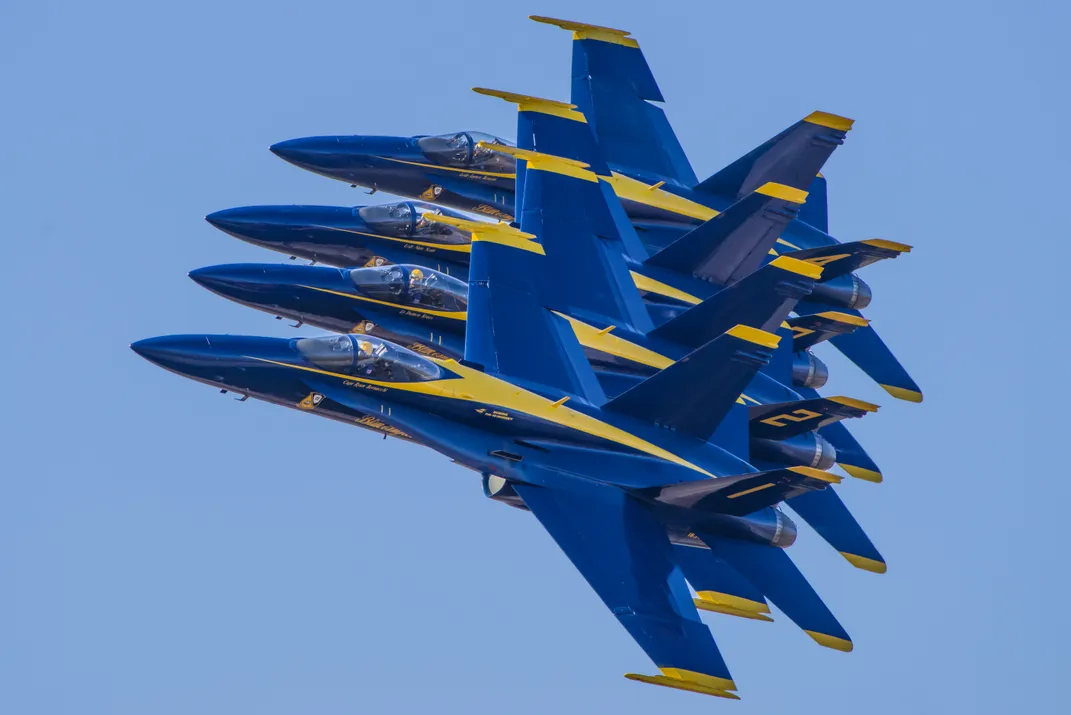 gold and blue fighter jets in formation in the sky