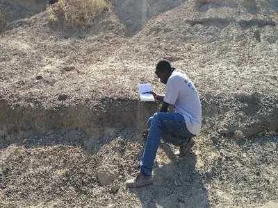 Sylvester Musembi Musyoka, a Kenyan colleague and field crew leader, recording a large mammal fossil bone during a virtual field project to collect fossils in Kenyan excavation sites that were in danger of being damaged by severe weather. 
