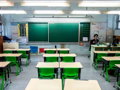 In this photo taken on March 6, 2020, primary school teacher Billy Yeung records a video lesson for his students, who have had their classes suspended due to coronavirus, in his empty classroom in Hong Kong.