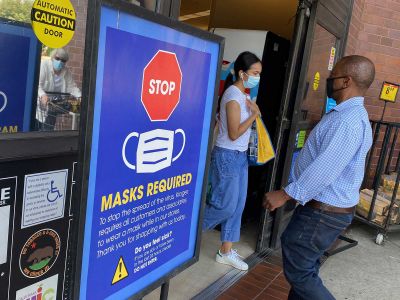 Individuals wear masks while shopping at a grocery store in Los Angeles. Masks help prevent breakthrough infections.