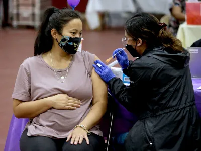 A woman who is six months pregnant receives a Covid booster shot in Los Angeles. The CDC advises pregnant women to get vaccinated.