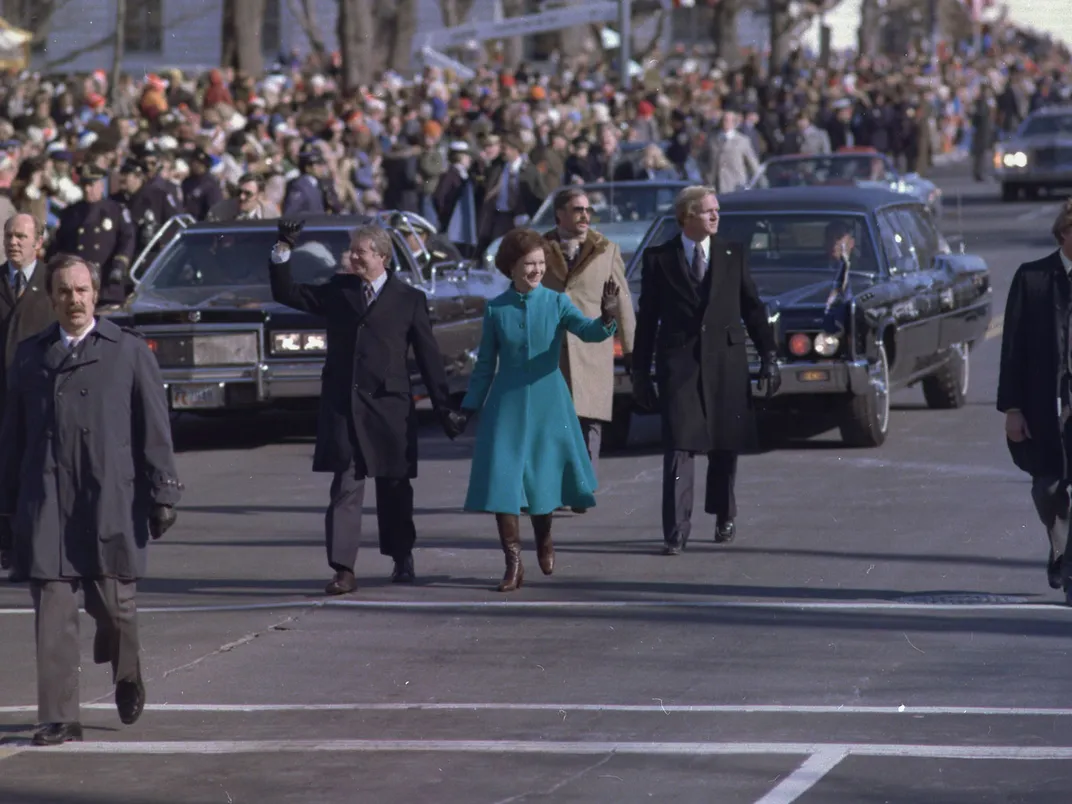 Rosalynn and Jimmy Carter walk down Pennsylvania Avenue during the 1977 Inaugural Parade.