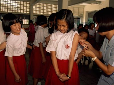 School girls line up to receive vaccinations between classes. 