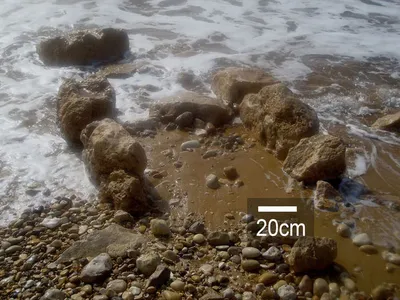 Exposed stone-built features in shallow water at the archaeological site of Tel Hreiz.