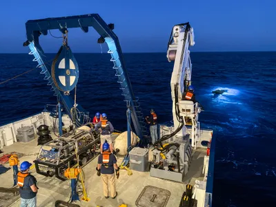 The Nautilus, a research vessel operated by the Ocean Exploration Trust, and the ROV Hercules (in the water) on the hunt for a cancer-busting marine bacteria.