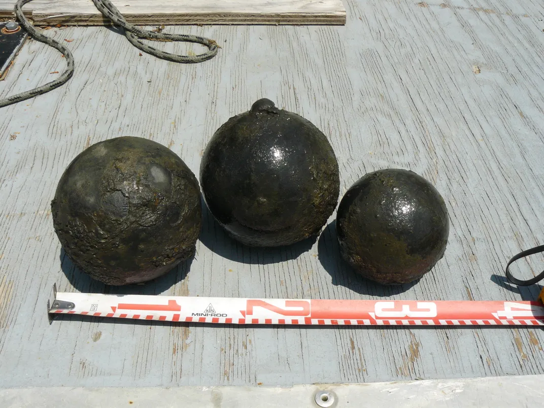 Spherical ammunitions next to a measuring tape