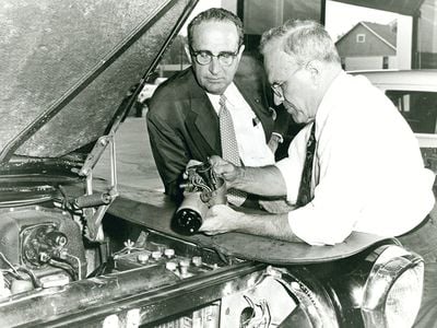 Ralph Teetor (right), cruise control in hand, with William Prossner, president of Perfect Circle, in 1957.